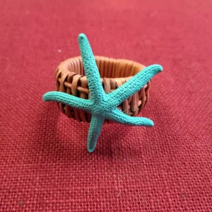 Servilletero estrella de mar albina natural en turquesa sobre bambú ancho